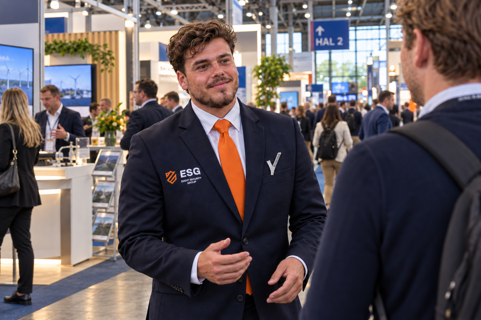 ESG-medewerker in gesprek met een bezoeker tussen de stands op een beurs