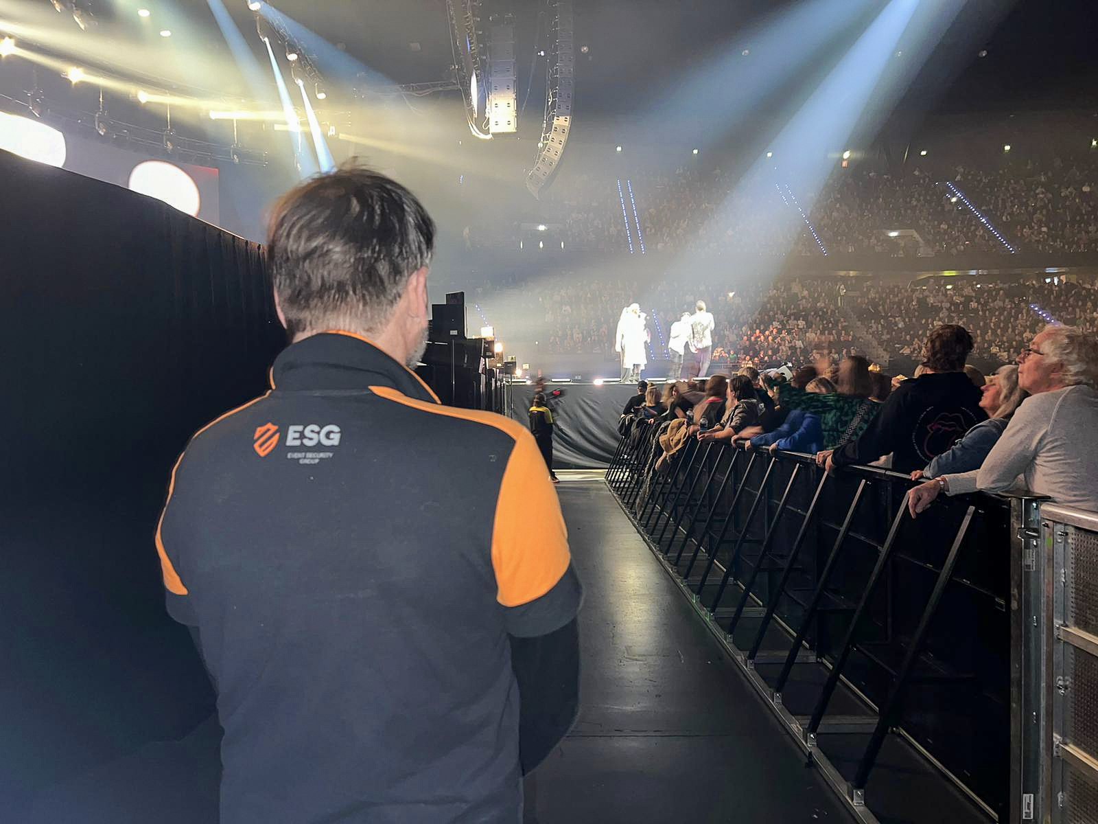 ESG-medewerker bij de publieksafzetting naast een concertpodium